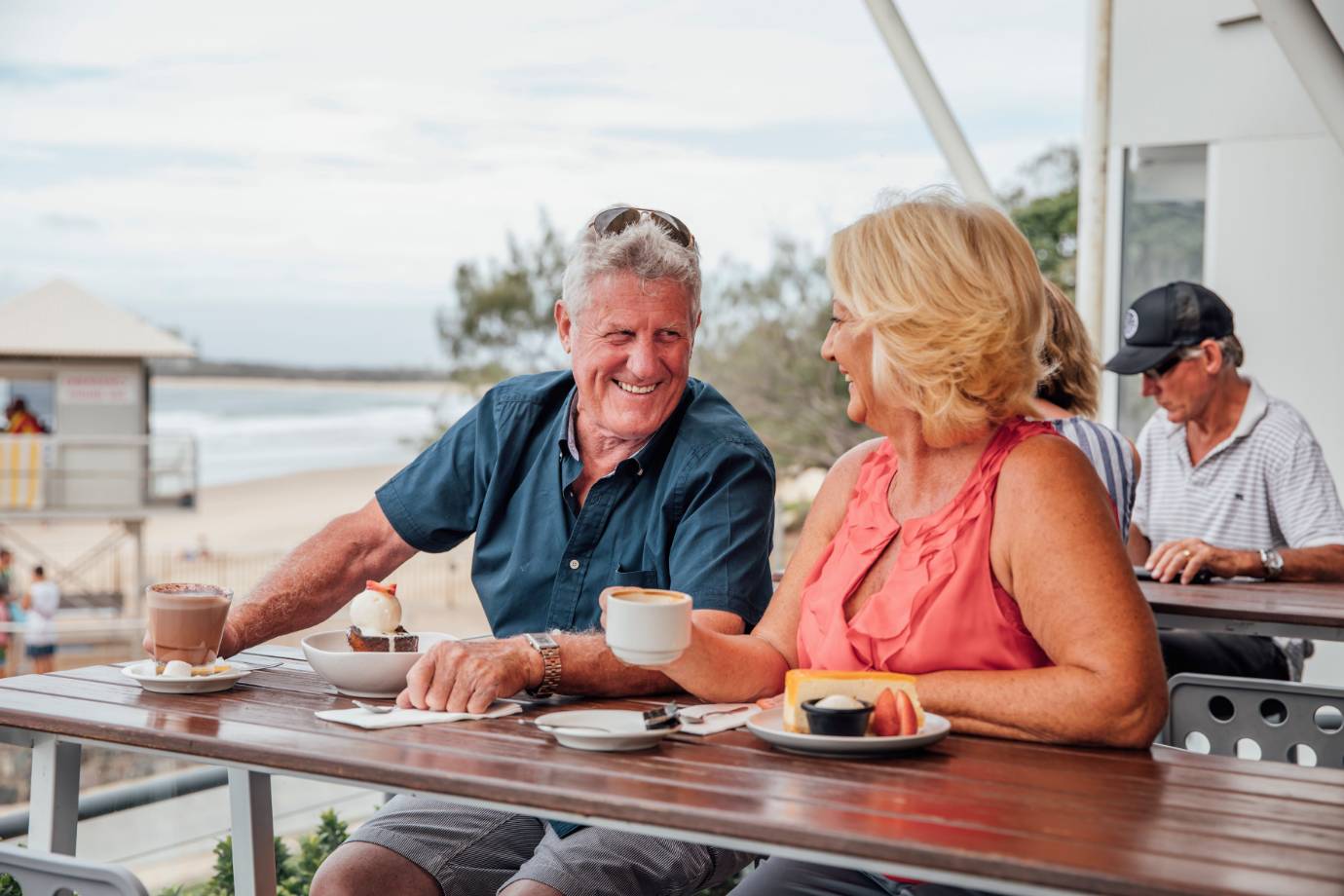 mooloolaba-surf-club-elderly-couple-on-deck-next-to-beach-drinking-coffee