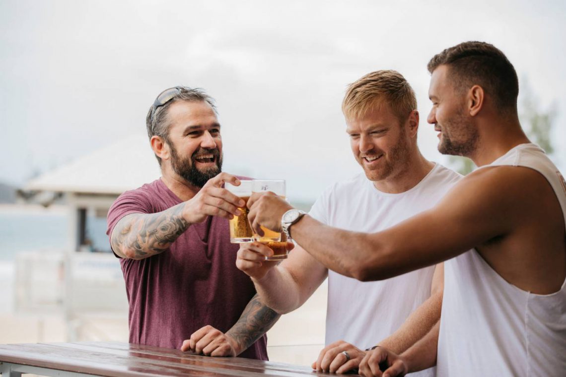 mooloolaba-surf-club-three-men-on-deck-saying-cheers-with-beer