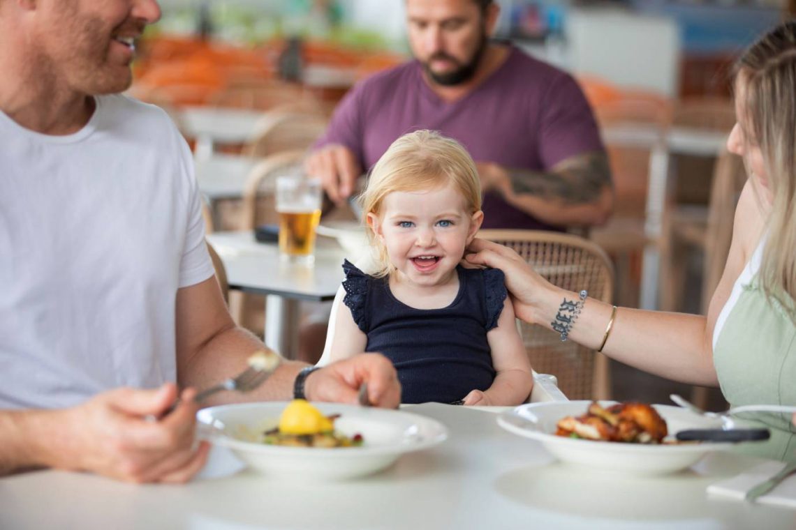 mooloolaba-surf-club-young-family-enjoying-meal-with-smiling-child